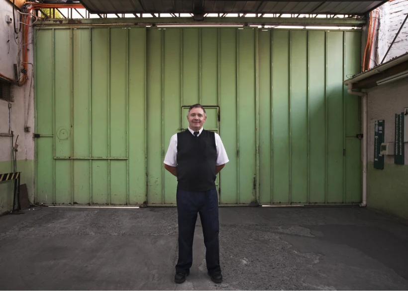 Man standing in front of green gate