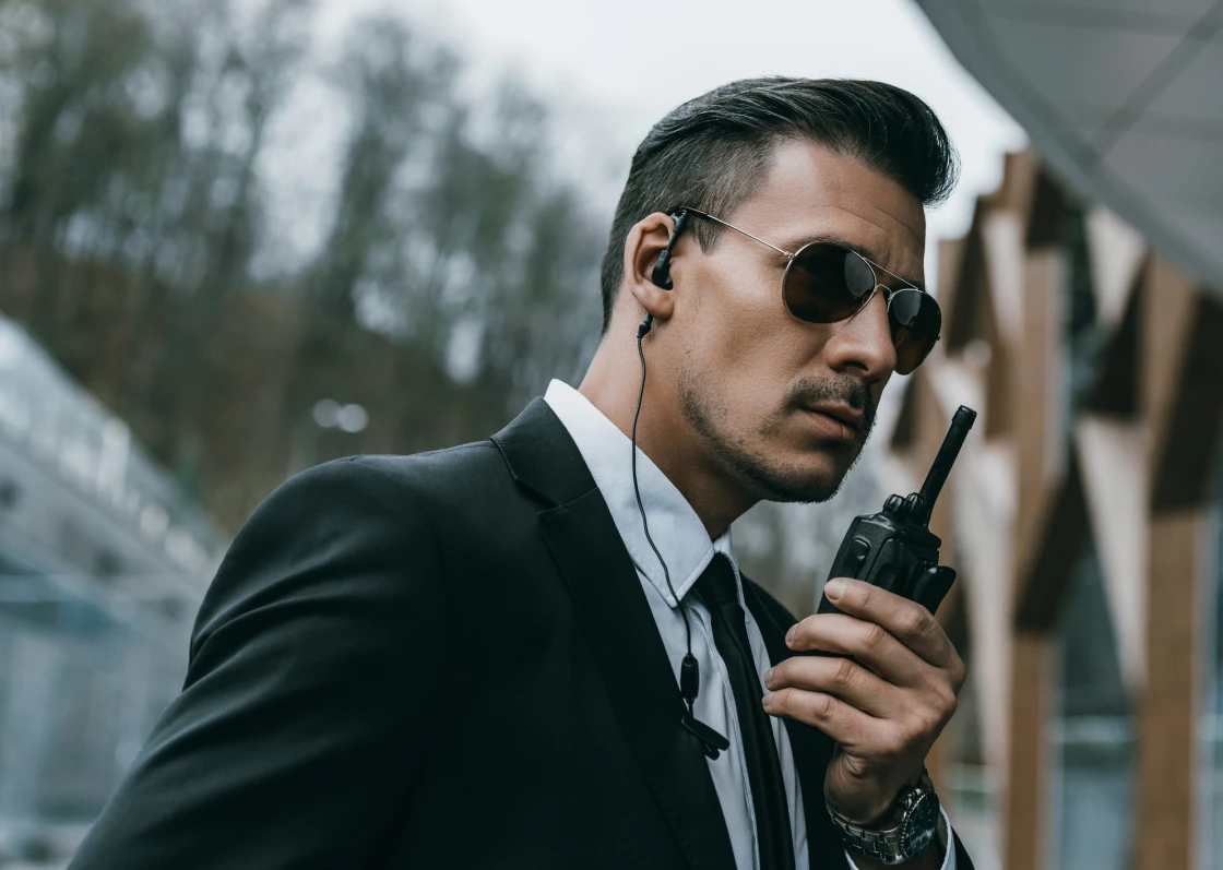 Sunglasses-wearing man communicating via radio