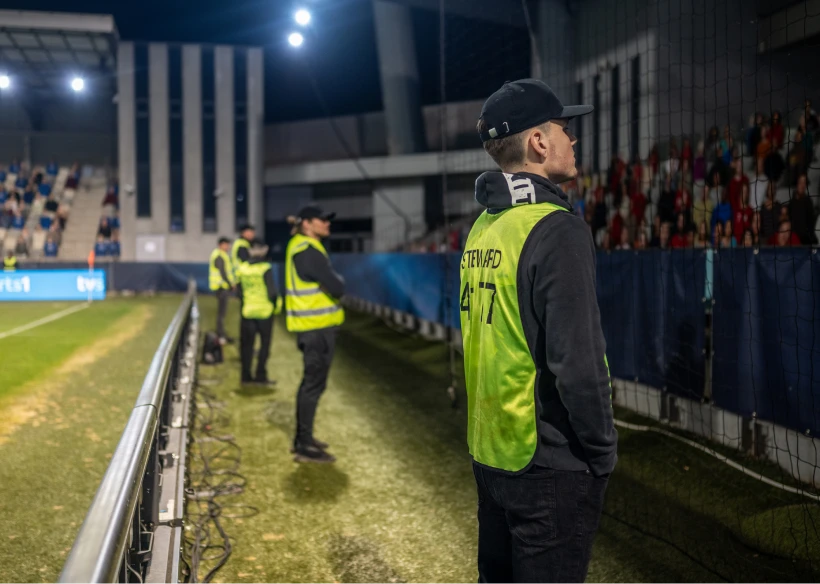 Stewards observing crowd at night game
