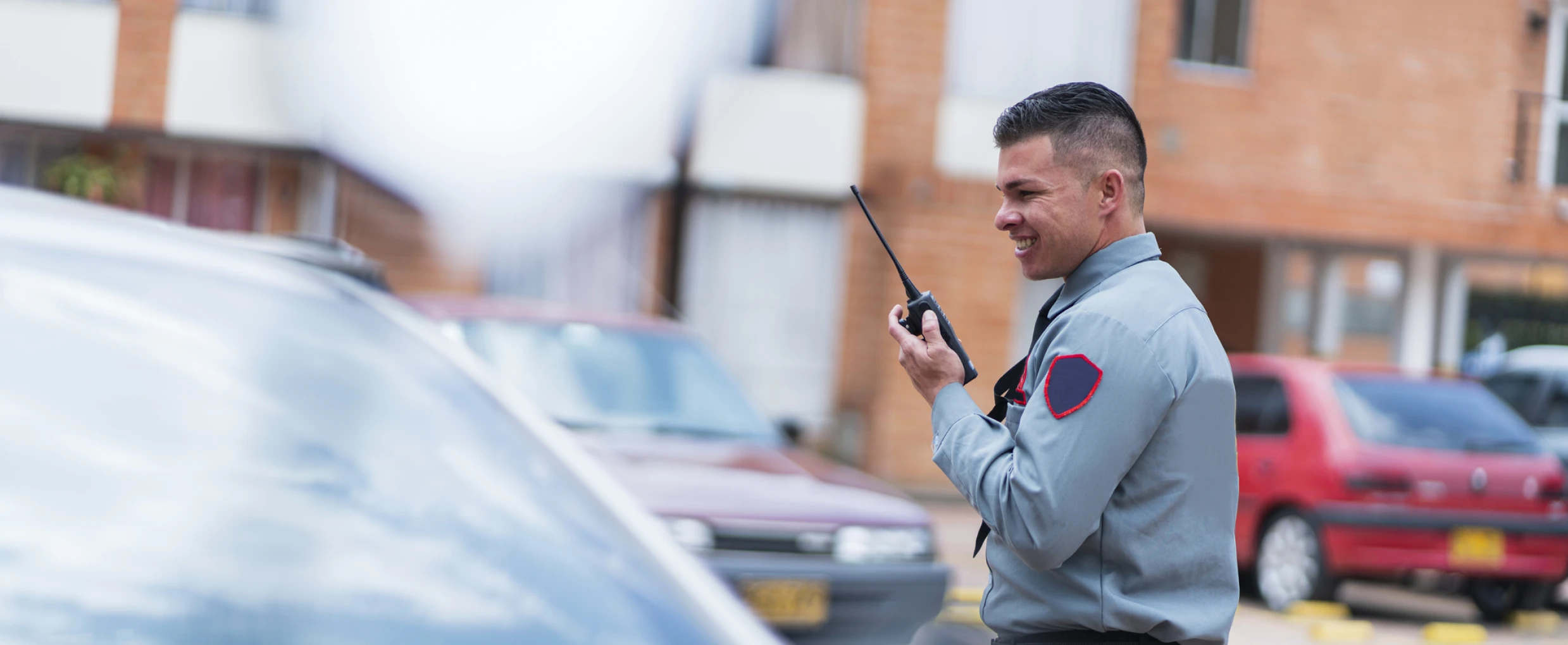 Guard communicating via radio near parked cars